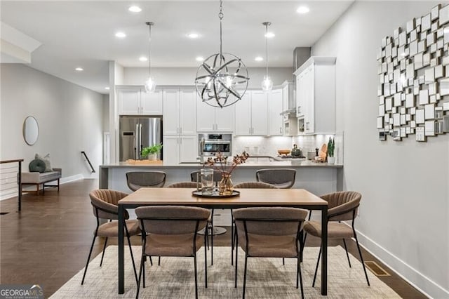 dining area with dark wood-type flooring and a chandelier