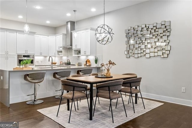 dining space featuring sink and dark wood-type flooring