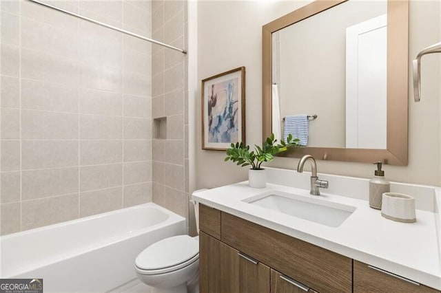 full bathroom featuring tiled shower / bath, vanity, and toilet