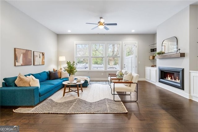 living room featuring ceiling fan and dark hardwood / wood-style flooring