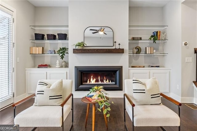 sitting room featuring dark hardwood / wood-style floors, ceiling fan, and built in shelves