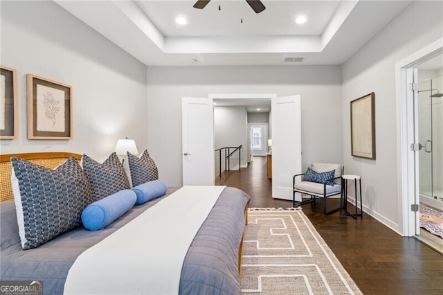 bedroom with a tray ceiling and dark hardwood / wood-style flooring