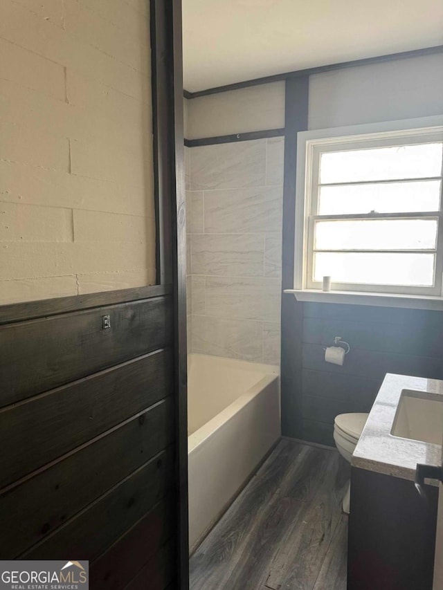 bathroom with vanity, hardwood / wood-style flooring, toilet, and a bathing tub