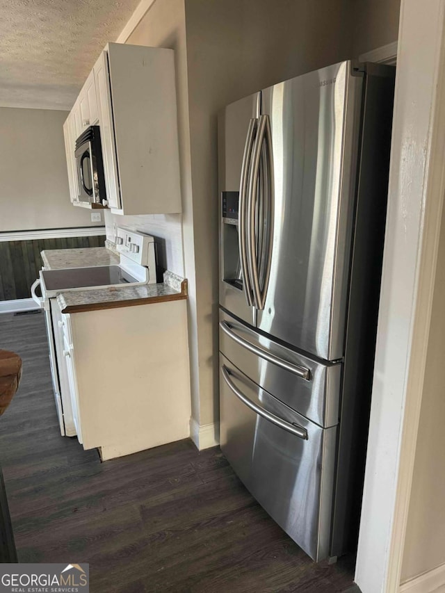 kitchen with a textured ceiling, electric range, stainless steel fridge, dark hardwood / wood-style flooring, and white cabinets