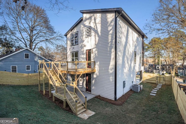 back of house featuring a lawn, a fenced backyard, stairs, a deck, and central AC