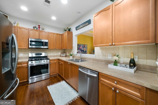 kitchen with appliances with stainless steel finishes, sink, dark hardwood / wood-style floors, and decorative backsplash