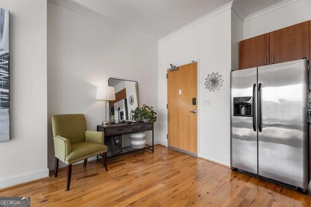 kitchen featuring ornamental molding, stainless steel fridge with ice dispenser, and light hardwood / wood-style flooring