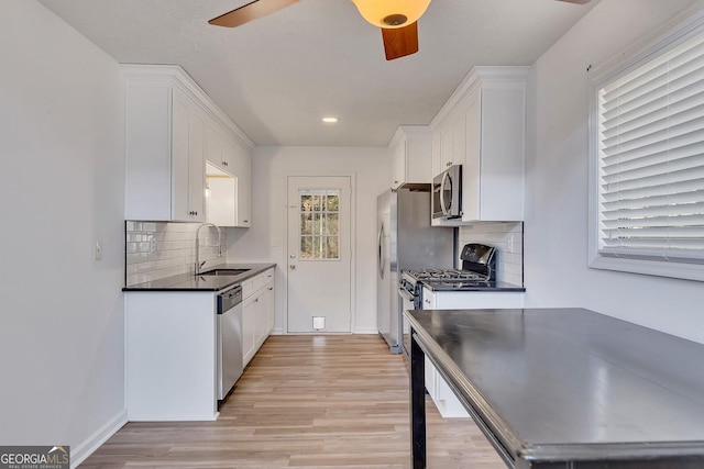 kitchen featuring white cabinetry, sink, ceiling fan, light hardwood / wood-style floors, and stainless steel appliances