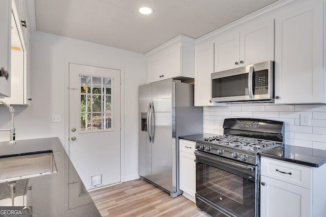 kitchen featuring white cabinetry, appliances with stainless steel finishes, and tasteful backsplash