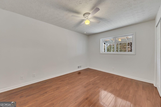 spare room with hardwood / wood-style flooring, a textured ceiling, and ceiling fan