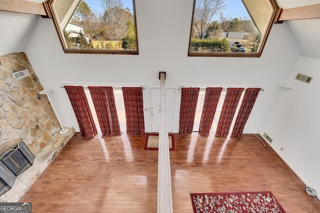 interior space with hardwood / wood-style flooring, a fireplace, and high vaulted ceiling