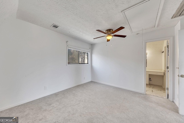 spare room with light colored carpet and a textured ceiling