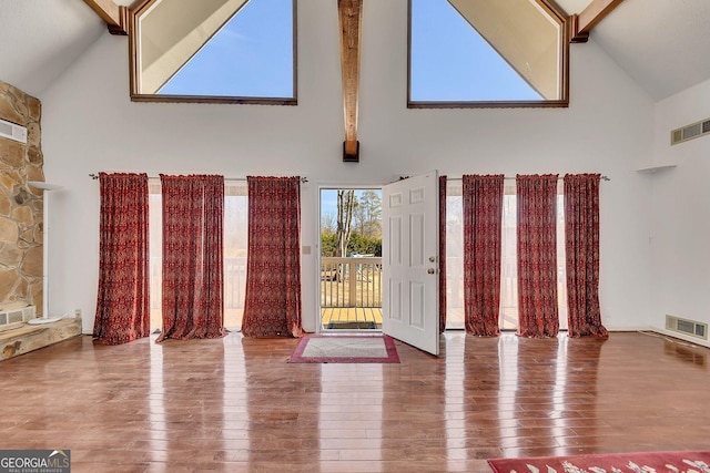 foyer featuring beam ceiling, wood-type flooring, and high vaulted ceiling