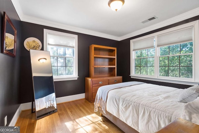 bedroom featuring hardwood / wood-style flooring and crown molding