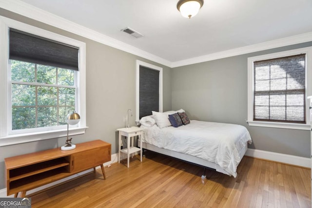 bedroom featuring crown molding and light hardwood / wood-style floors