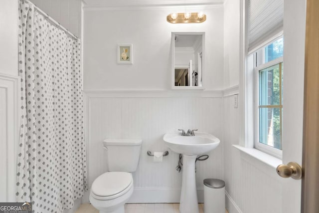 bathroom featuring walk in shower, tile patterned floors, toilet, and crown molding