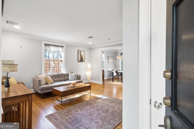 living room with ornamental molding and hardwood / wood-style floors