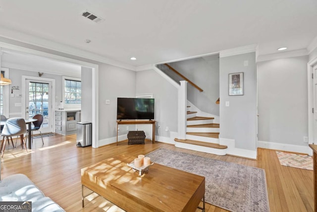 living room with crown molding and light hardwood / wood-style flooring