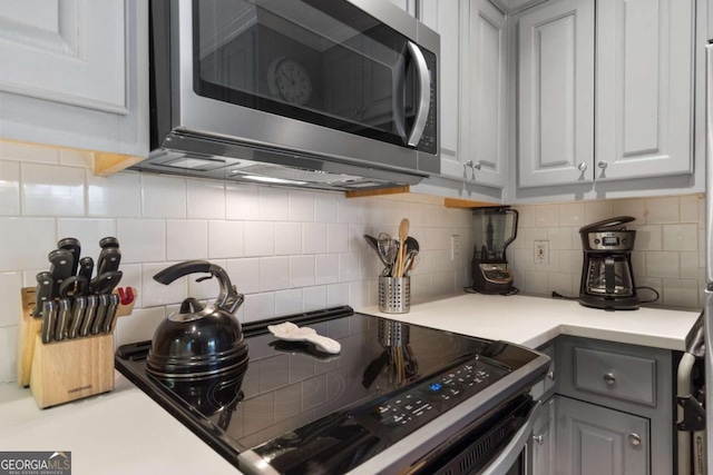 kitchen featuring backsplash, gray cabinets, and stainless steel appliances