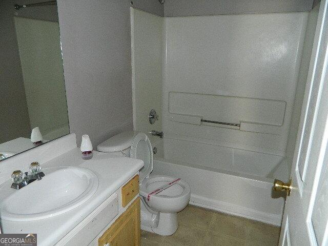 full bathroom featuring shower / bath combination, vanity, tile patterned floors, and toilet