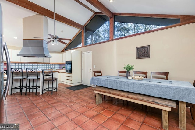 tiled dining space with beam ceiling, high vaulted ceiling, and ceiling fan