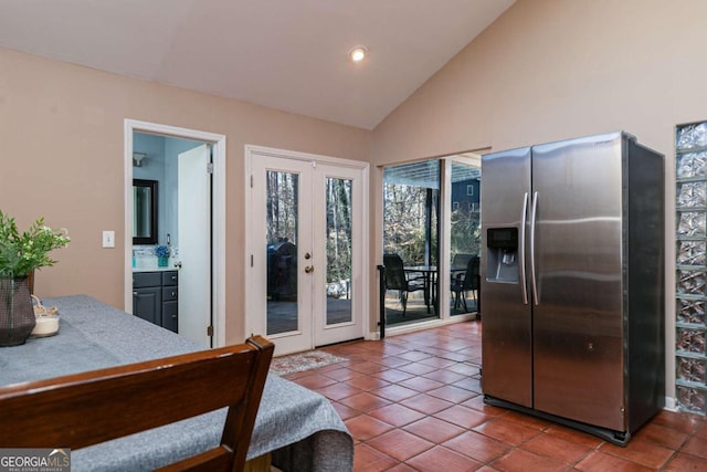 bedroom with vaulted ceiling, tile patterned flooring, access to outside, stainless steel fridge with ice dispenser, and french doors