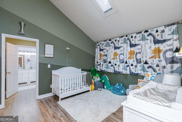 bedroom featuring hardwood / wood-style flooring, lofted ceiling with skylight, and a textured ceiling