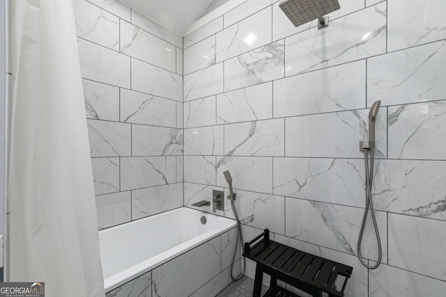 bathroom featuring vaulted ceiling and shower / bath combination with curtain