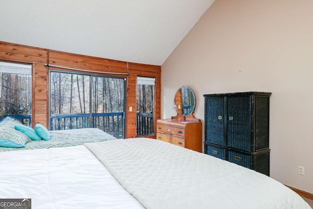 bedroom featuring lofted ceiling, access to outside, and wooden walls