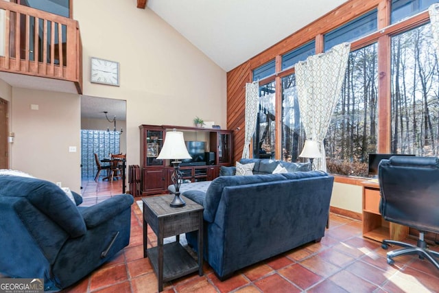 living room with tile patterned flooring, a chandelier, and high vaulted ceiling