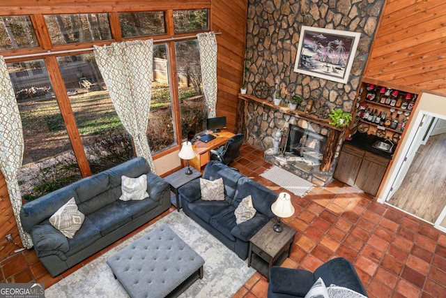 living room featuring a fireplace, a healthy amount of sunlight, and wooden walls