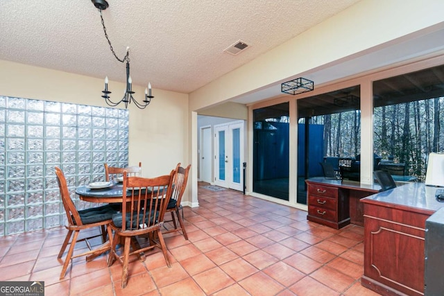 tiled dining area with a textured ceiling and a chandelier