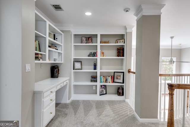 home office featuring decorative columns, ornamental molding, light carpet, and built in desk