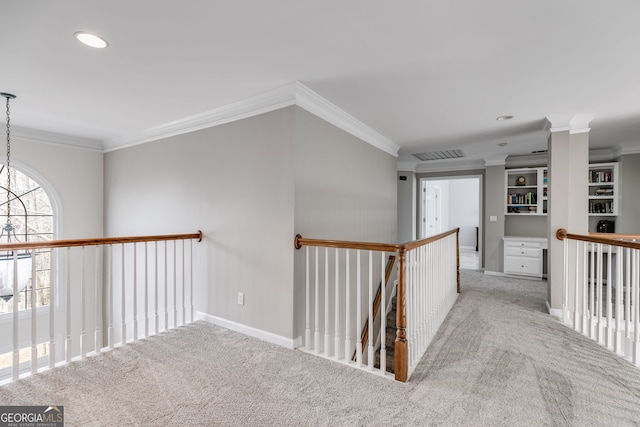 hall featuring a notable chandelier, crown molding, and light colored carpet