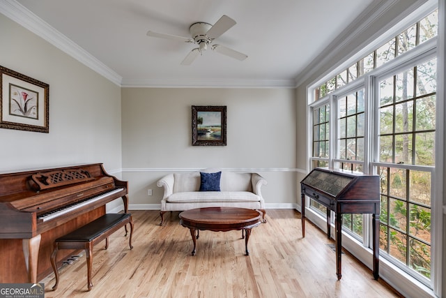 living area with crown molding, ceiling fan, and light hardwood / wood-style floors