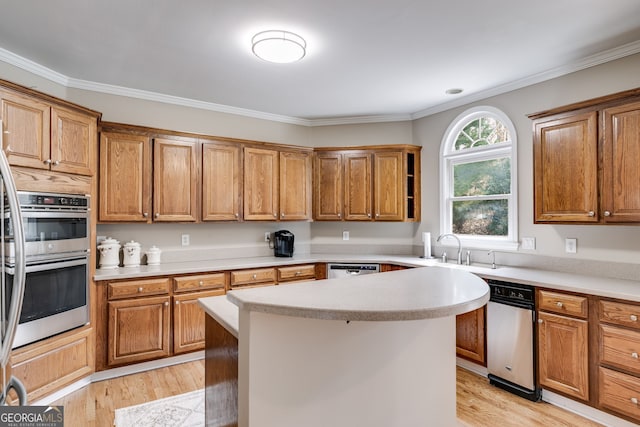 kitchen with sink, light hardwood / wood-style floors, a center island, and stainless steel double oven