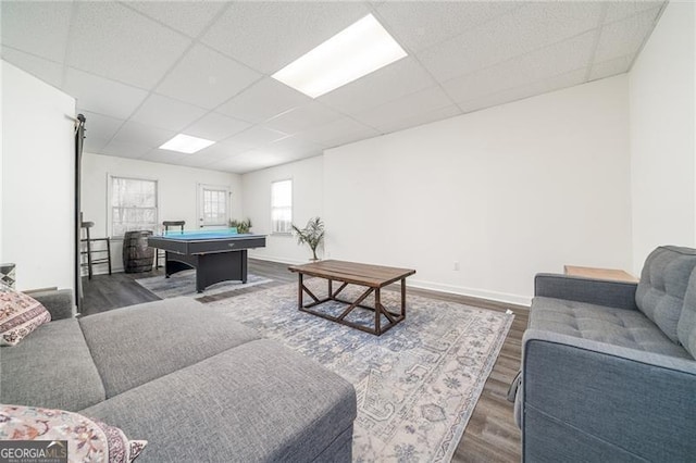 living room featuring dark wood-type flooring, pool table, and a drop ceiling