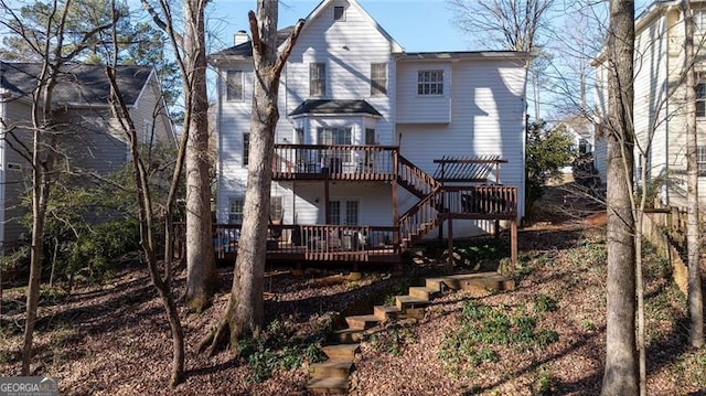 back of house with a pergola and a deck