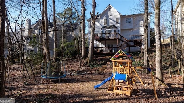 view of jungle gym featuring a trampoline and a wooden deck