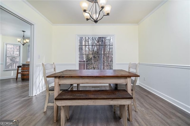 dining area with ornamental molding, dark wood-type flooring, and a chandelier