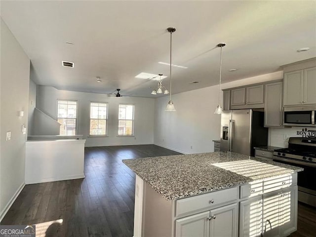 kitchen with gray cabinetry, dark hardwood / wood-style floors, a kitchen island, ceiling fan, and stainless steel appliances