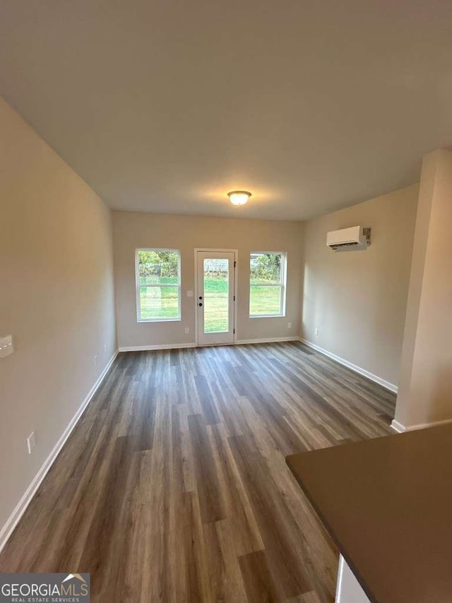 unfurnished living room featuring dark hardwood / wood-style floors and a wall mounted AC