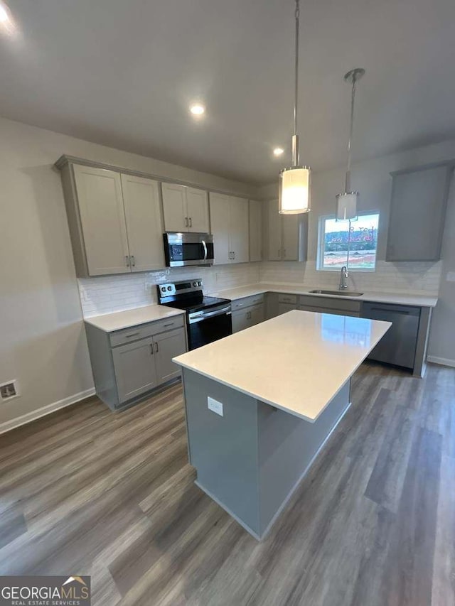 kitchen with a kitchen island, sink, gray cabinets, and appliances with stainless steel finishes