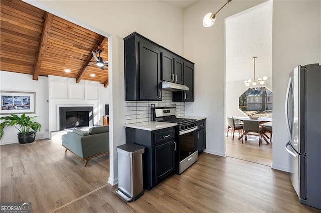 kitchen with appliances with stainless steel finishes, high vaulted ceiling, beamed ceiling, backsplash, and wooden ceiling