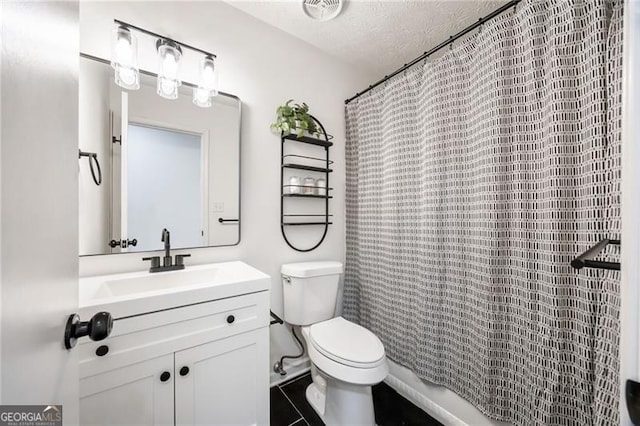 bathroom with vanity, toilet, and a textured ceiling