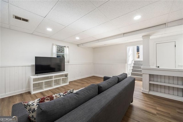 living room with a drop ceiling and dark hardwood / wood-style flooring