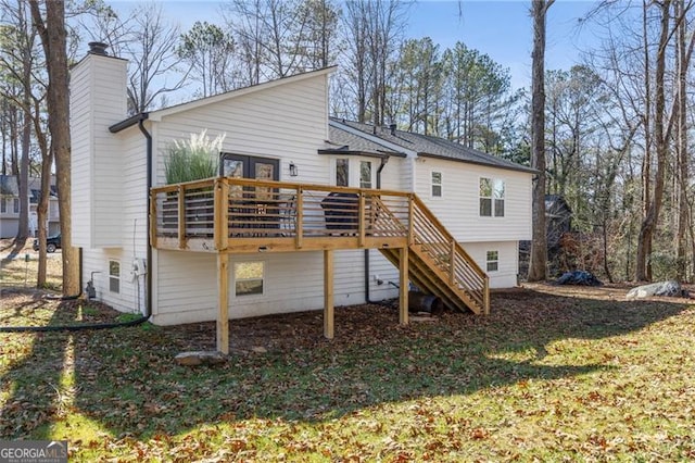 rear view of property featuring a yard and a deck