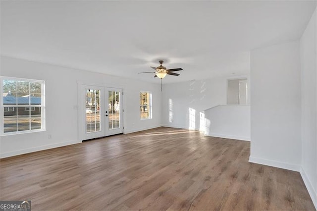 unfurnished living room with french doors, ceiling fan, and hardwood / wood-style flooring