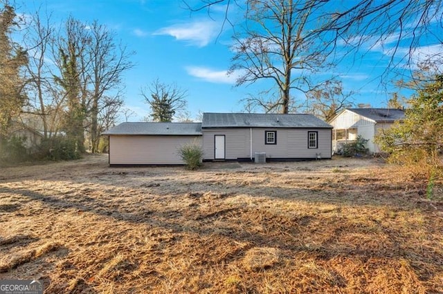 back of property with a yard and central air condition unit