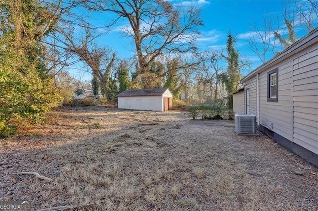 view of yard featuring a storage shed and central AC unit